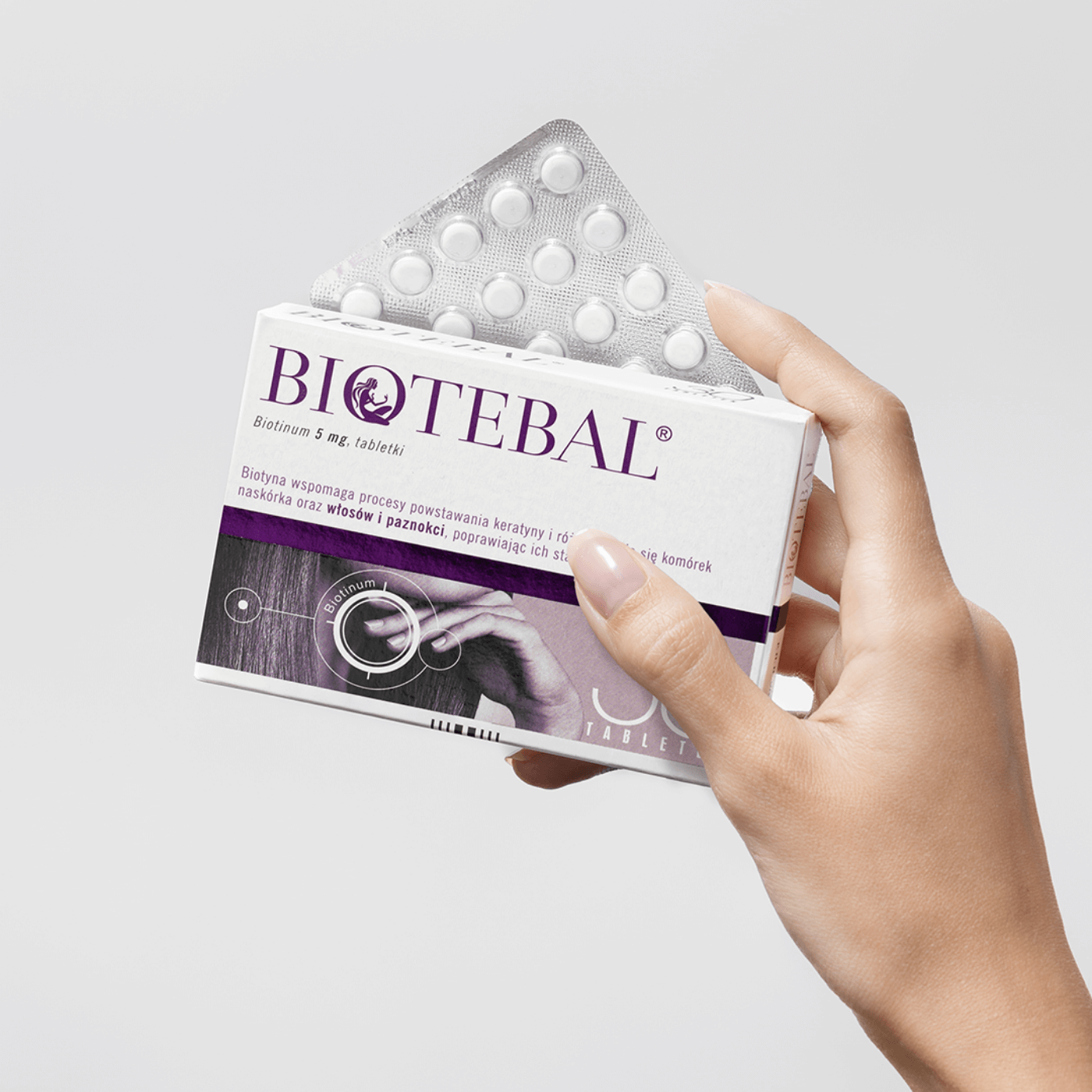 Dłoń trzymająca packshot Biotebal lek