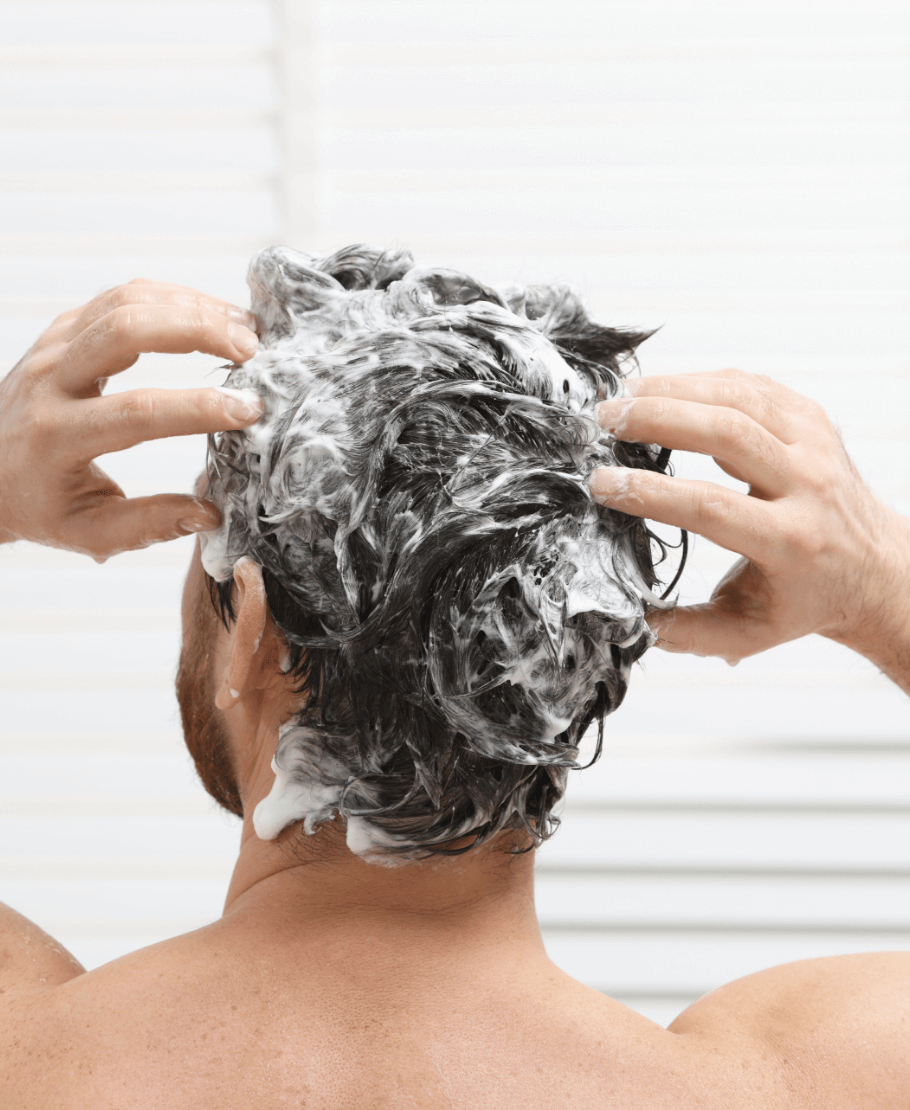 mężczyzna podczas mycia włosów