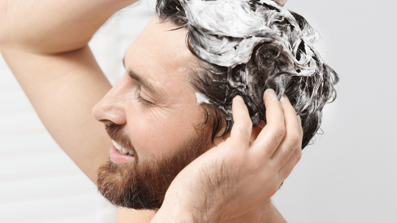mężczyzna podczas mycia włosów